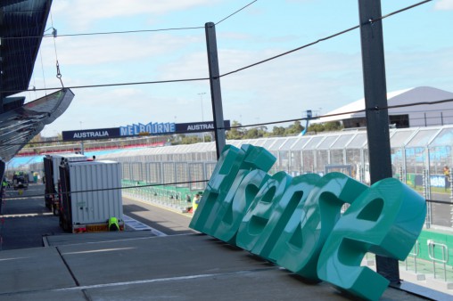 A Hisense sign leans against a fence.