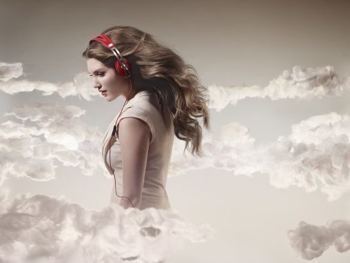 Parisian blogger Haleigh Walsworth flies through the clouds listening to Sennheiser Momentum headphones in red.