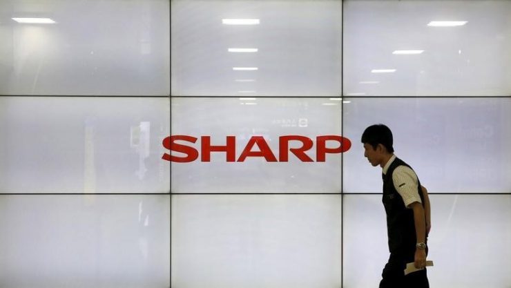 A man walks past display showing a logo of Sharp Corp in Tokyo, Japan, October 30, 2015. REUTERS/Toru Hanai
